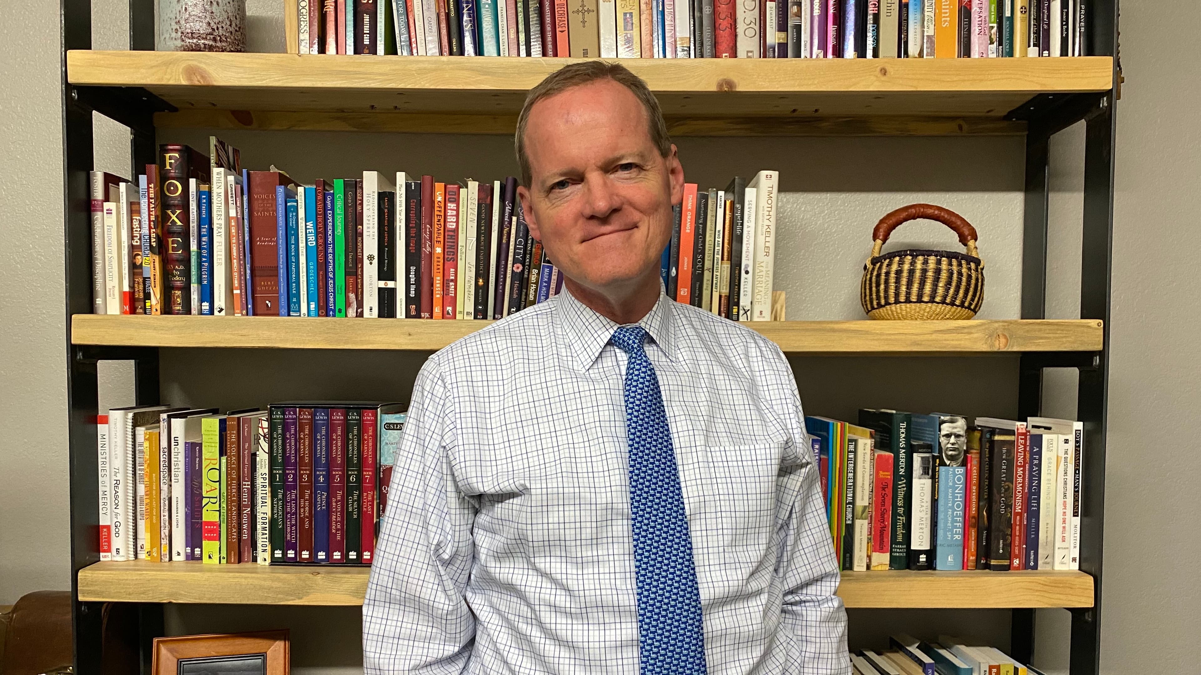 Gary G. Hoag standing in front of bookshelves