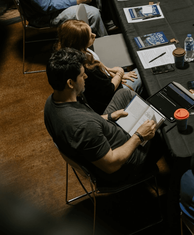 People gathered around a table reading generosity resources