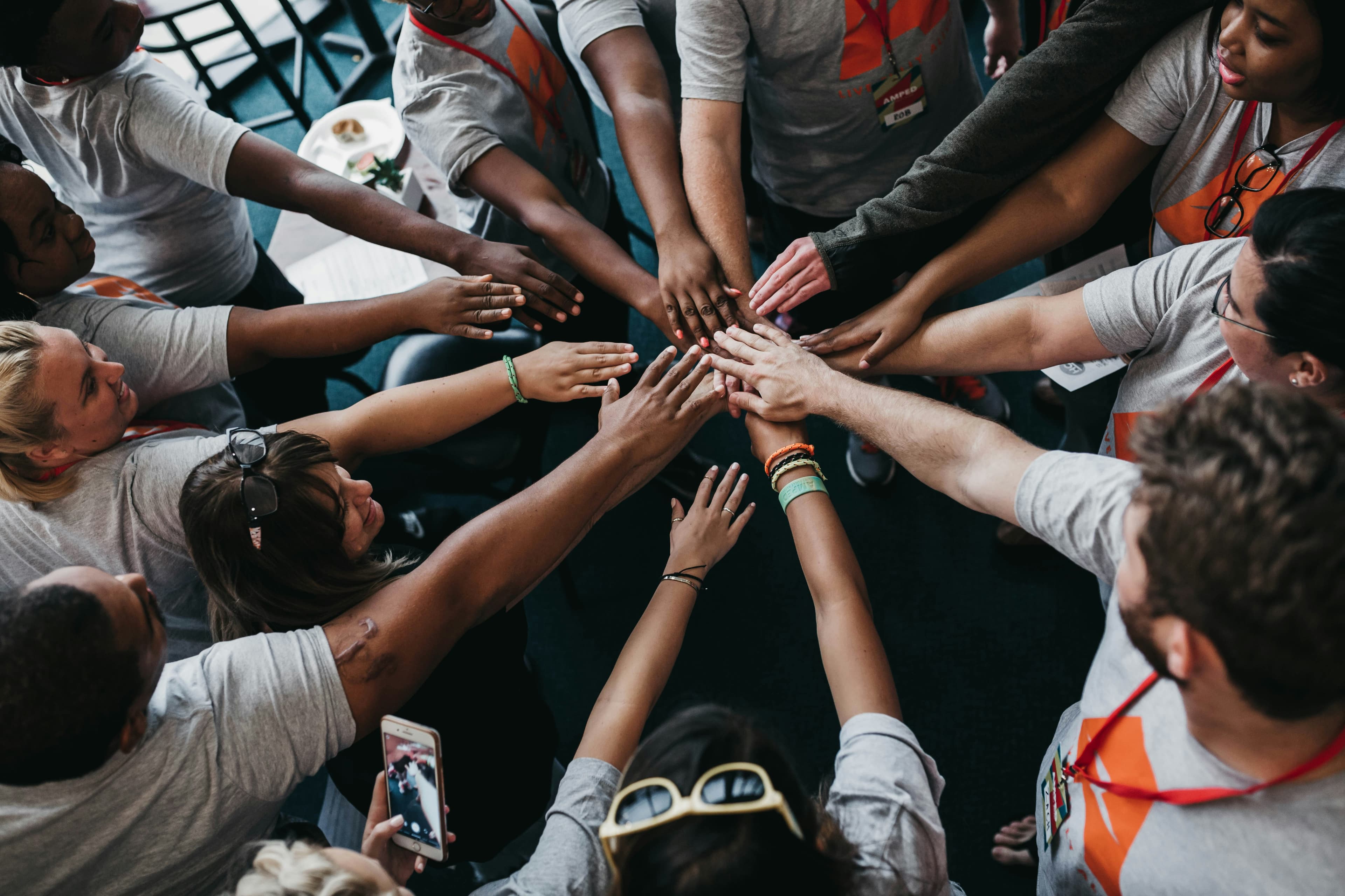 A diverse group of people joining hands in a circle